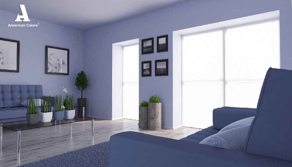 Sala de estar contemporánea con sofás modernos, ventanales grandes, plantas decorativas y marcos de fotos en la pared, mostrando una armonía de colores de azules 